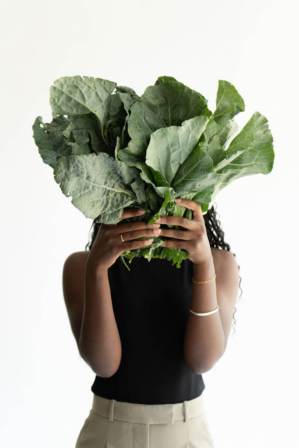Miriam Wood holding a bunch of leafy greens in front of her face